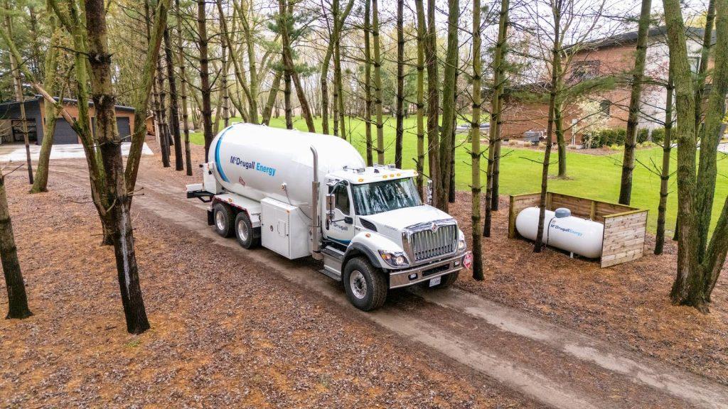 McDougall truck on dirt road in rural area in surrounded by trees and fall leaves