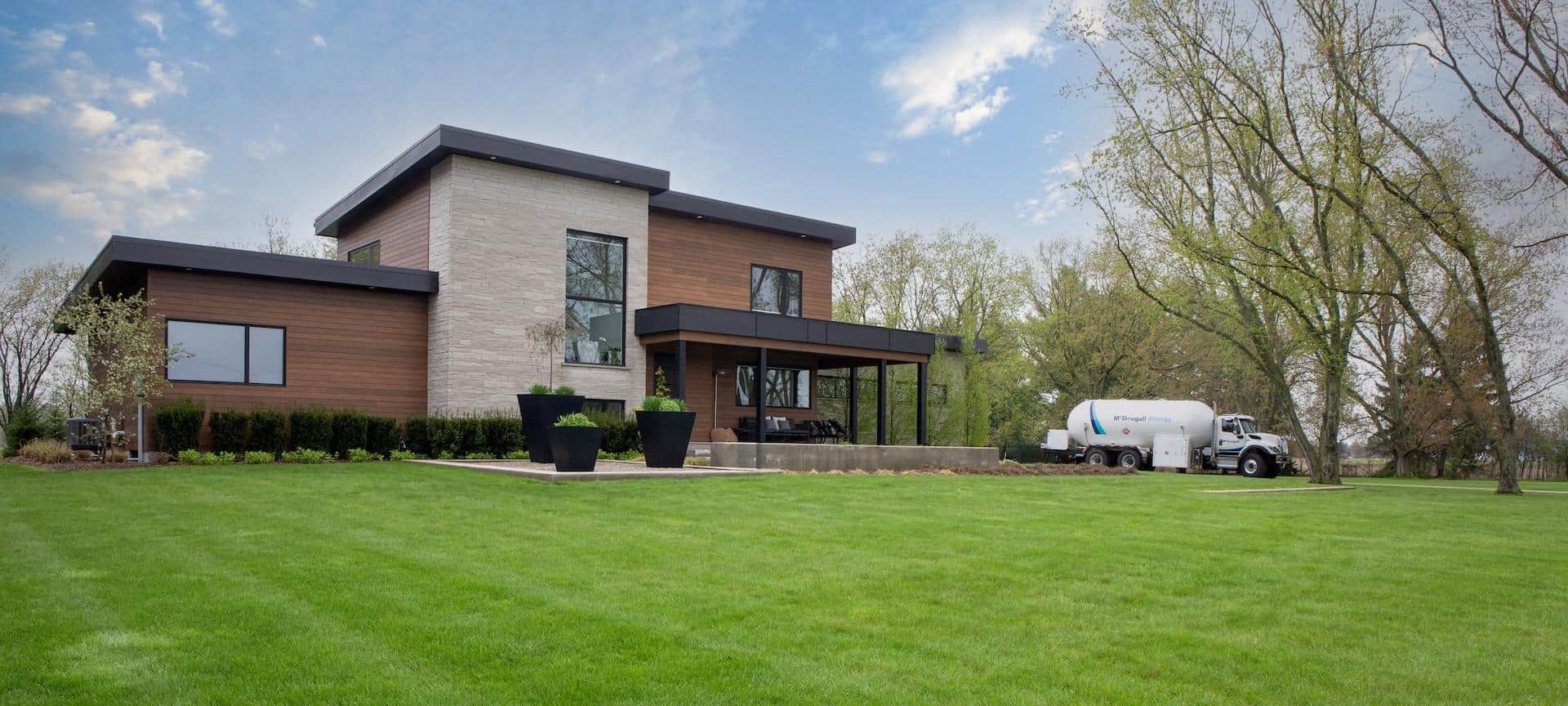 Home 1 Clean energy delivery at modern home with McDougall Energy propane delivery truck.